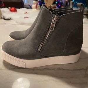 WEDGIE has a hidden wedge sole and convenient dual side zippers.